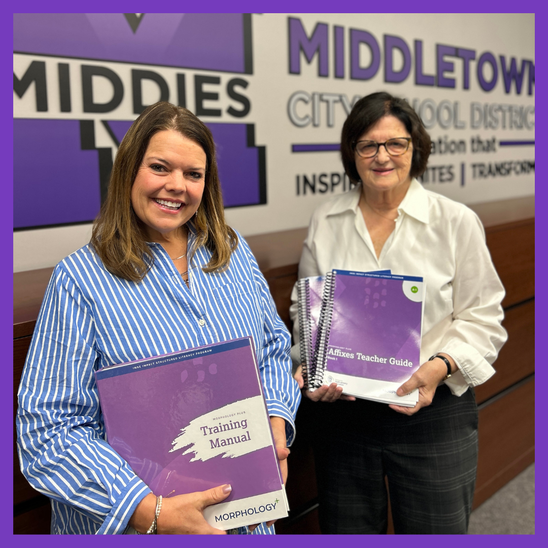 Terri and Cheryl pose in front of an MCSD sign holding up their morphology resources.